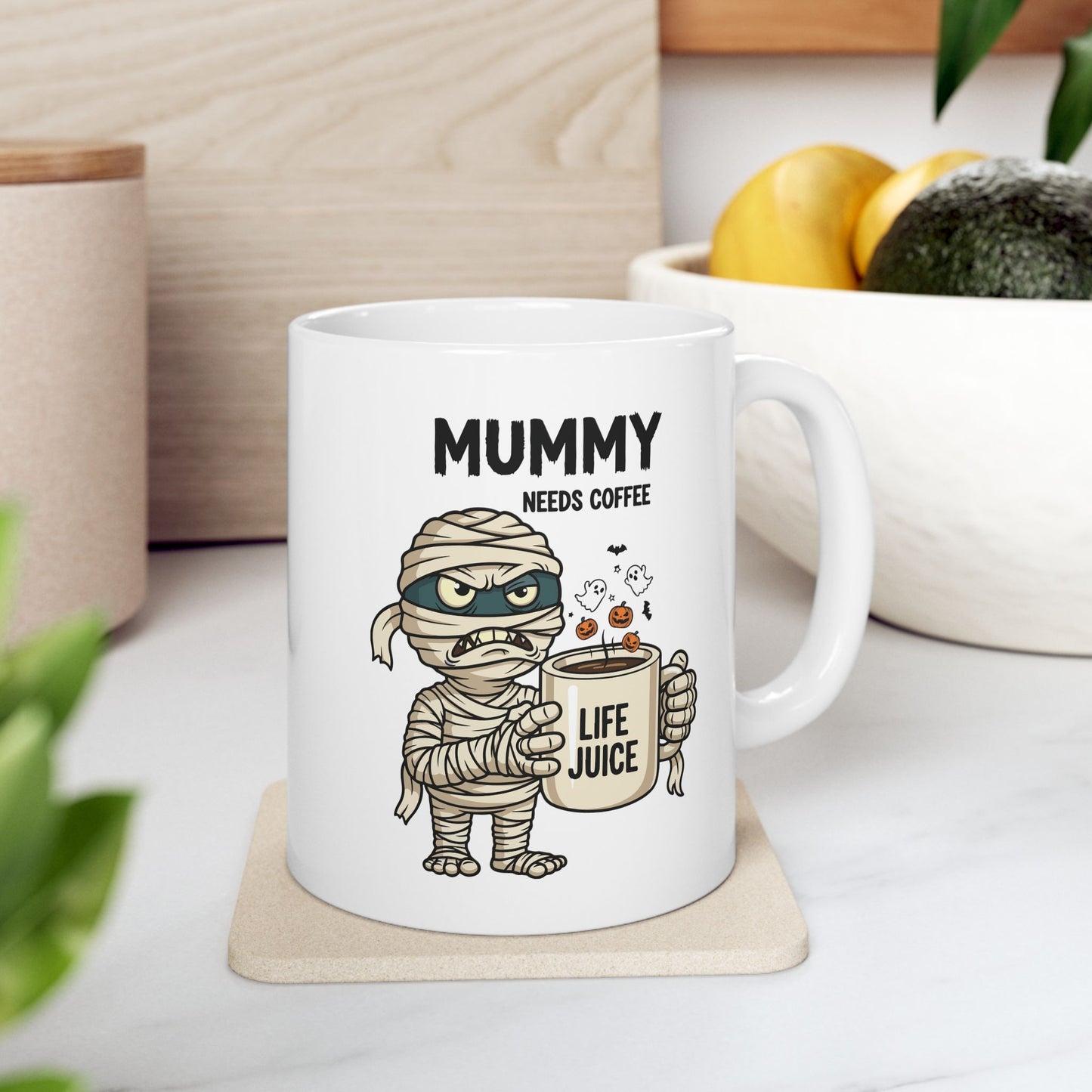 Halloween Mug with mummy design and text 'Mummy needs coffee life juice' on a coaster.