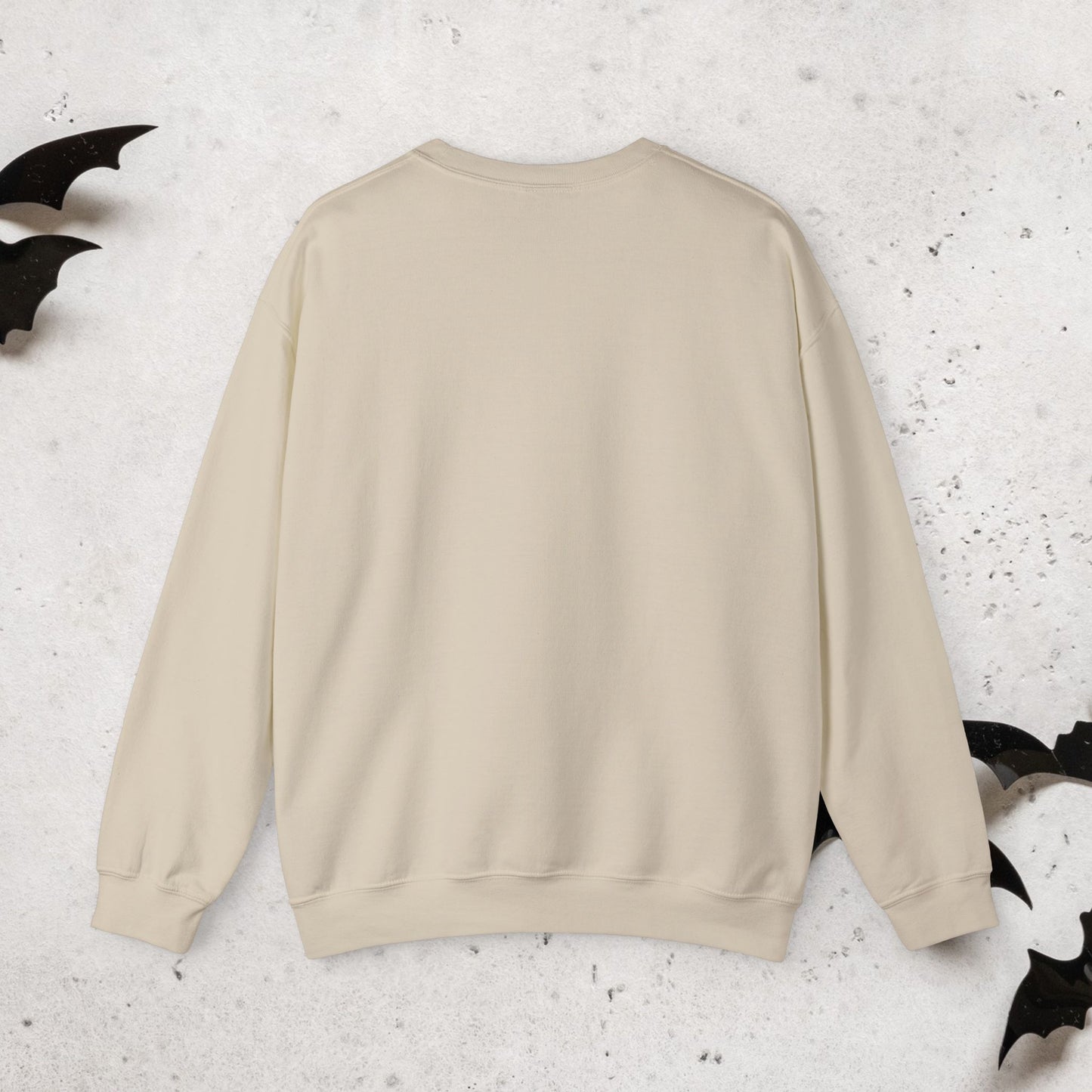 Back of Beige halloween crewneck sweatshirt on a textured white background