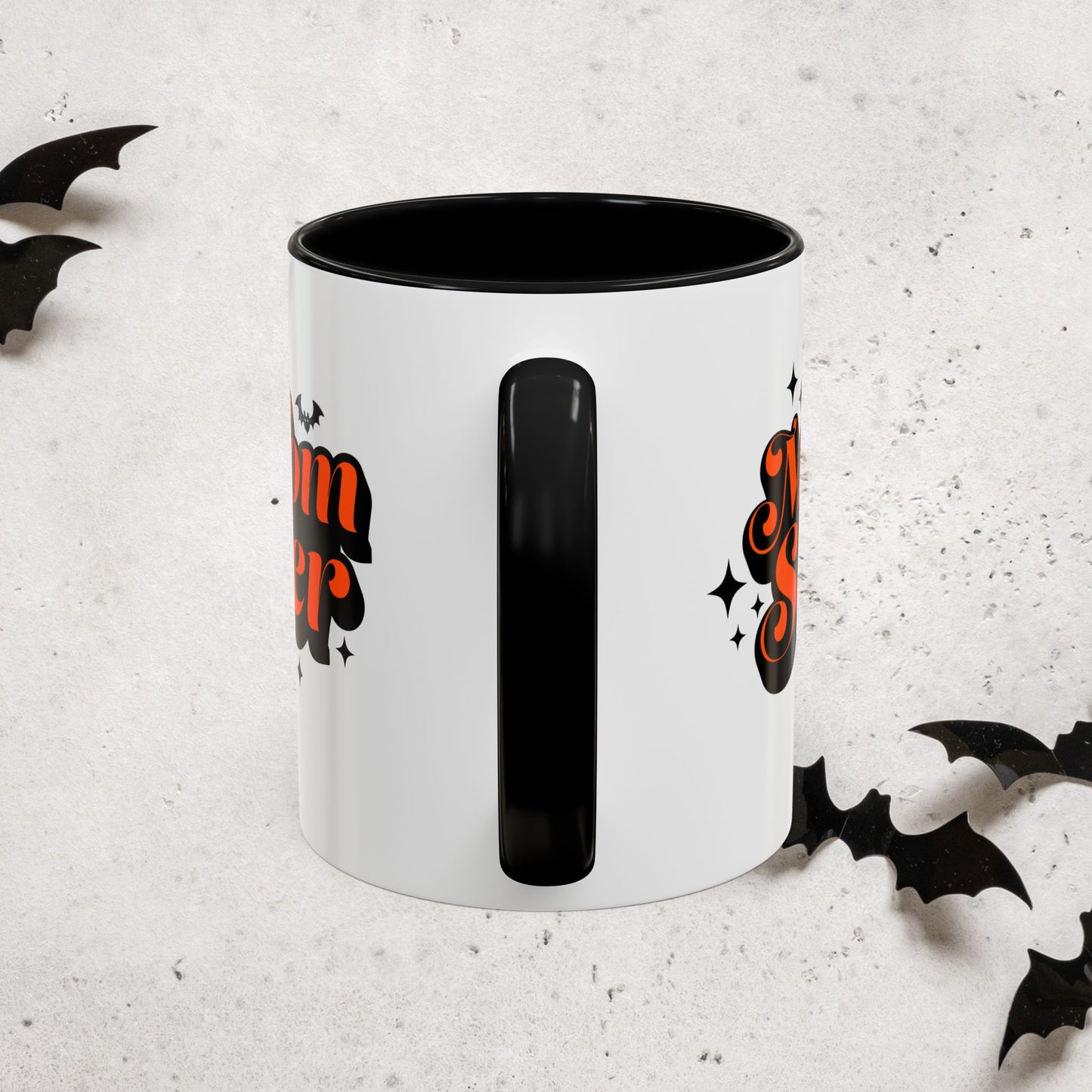 White Momster mug with black interior and handle, featuring Halloween-themed designs on a light gray background.