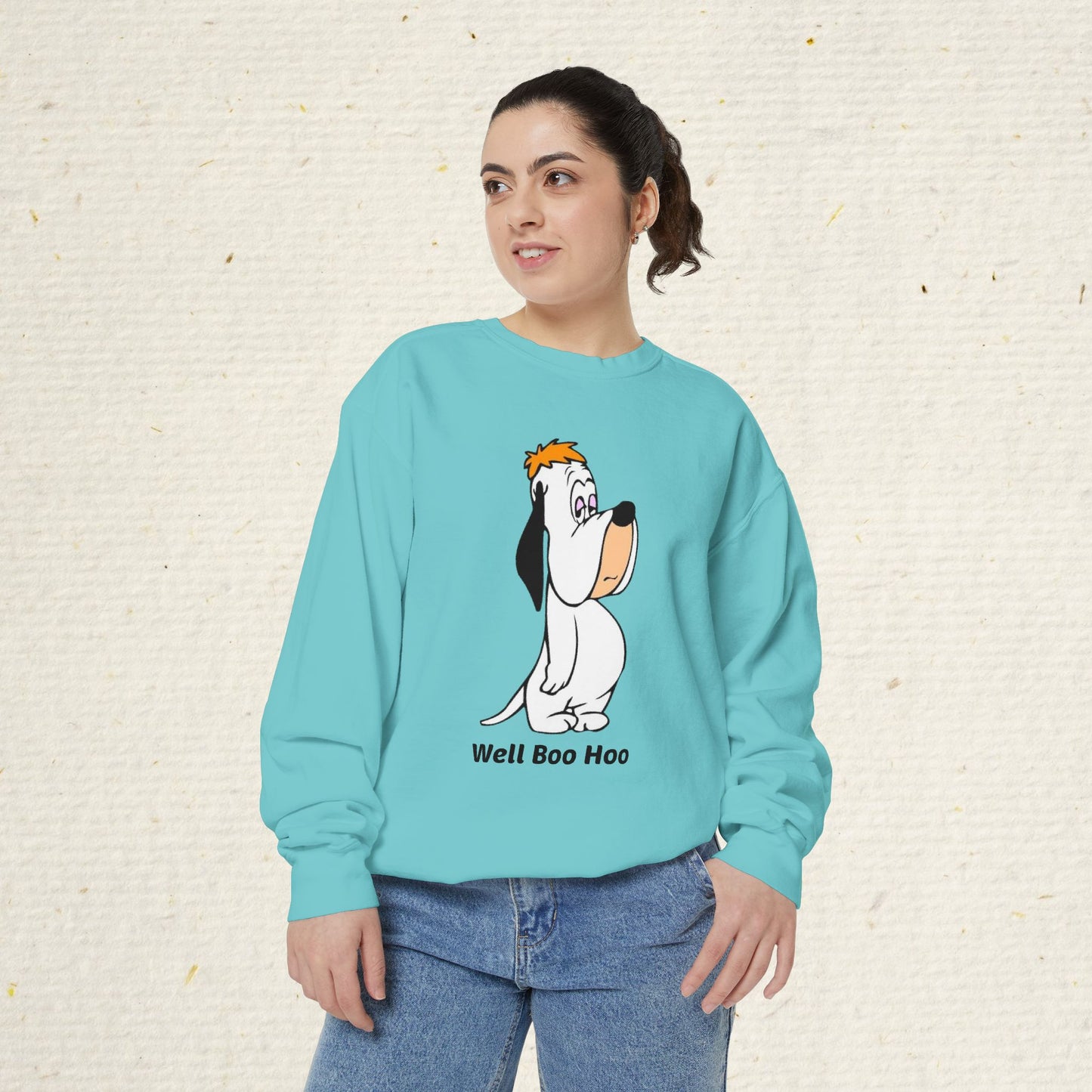 Person wearing a light blue sweatshirt with a cartoon droopy dog design and text on a beige background