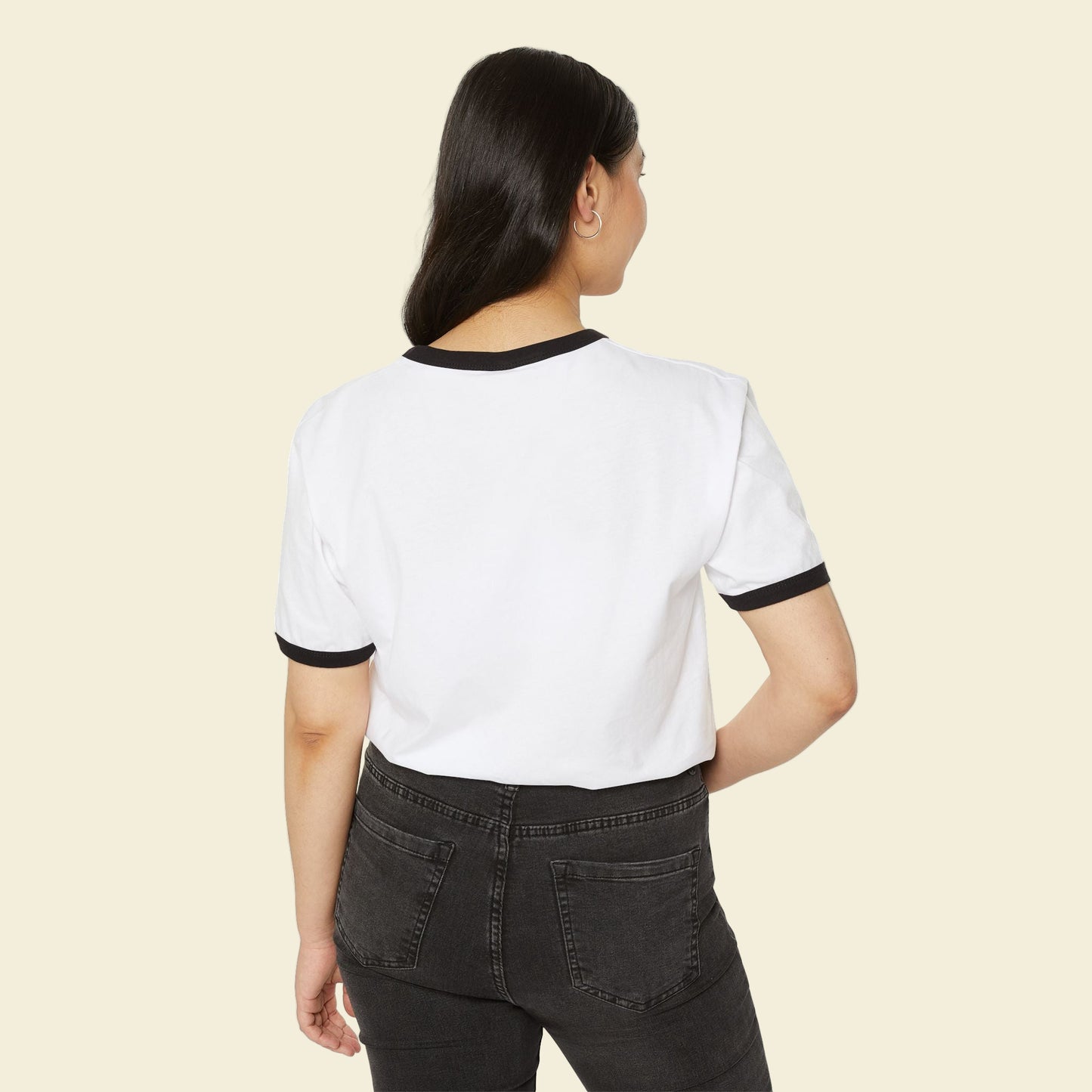 Person wearing a white back to school t-shirt with black trim and dark jeans on a white background