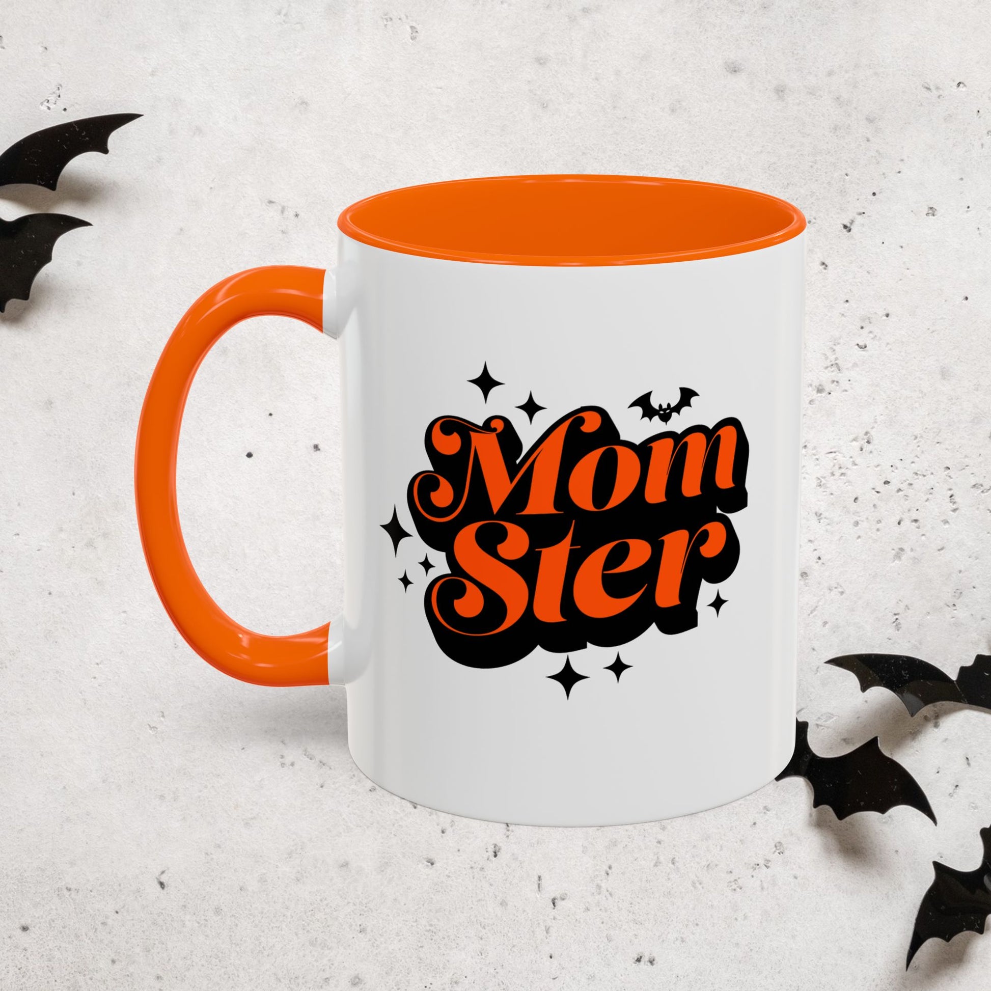 White Halloween mug with orange interior and handle, featuring 'MomSter' text on a light gray background with black bat decorations.