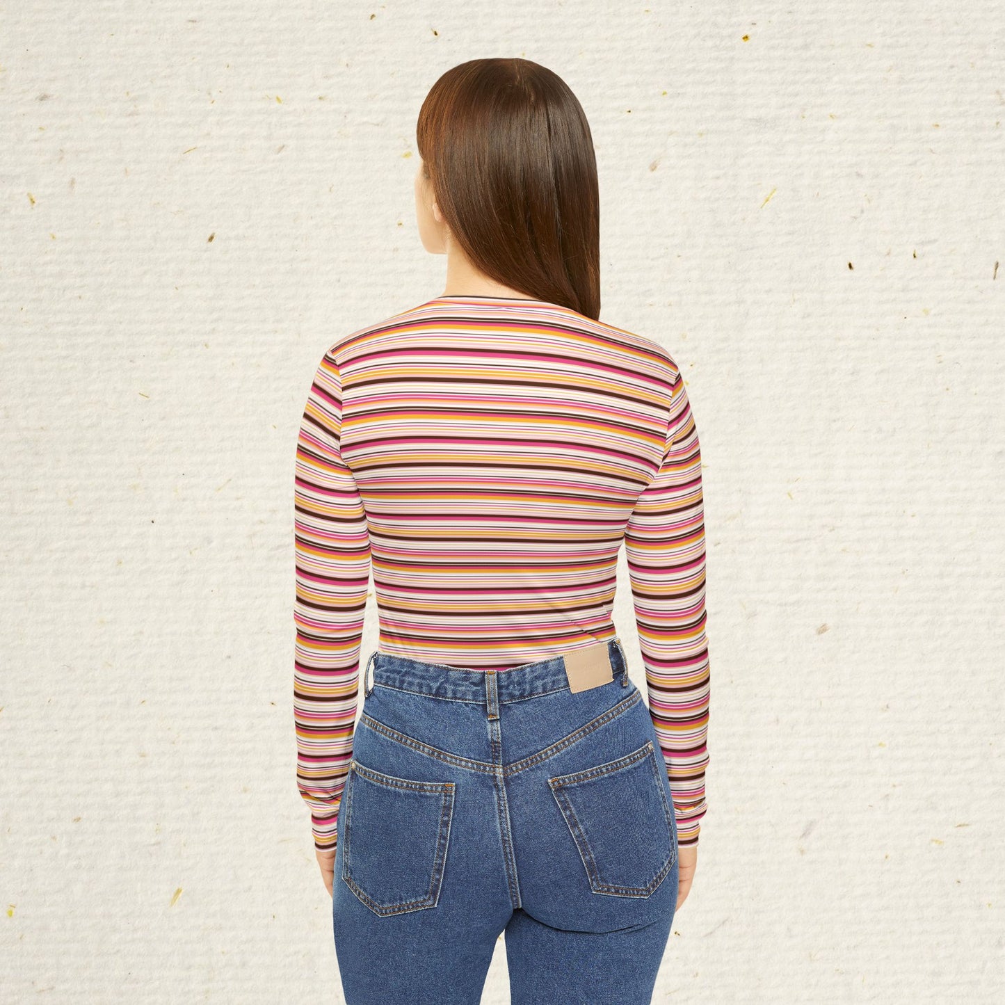 Woman wearing retro striped long sleeve V-neck top with vintage-inspired pink coral and gold stripes paired with jeans.