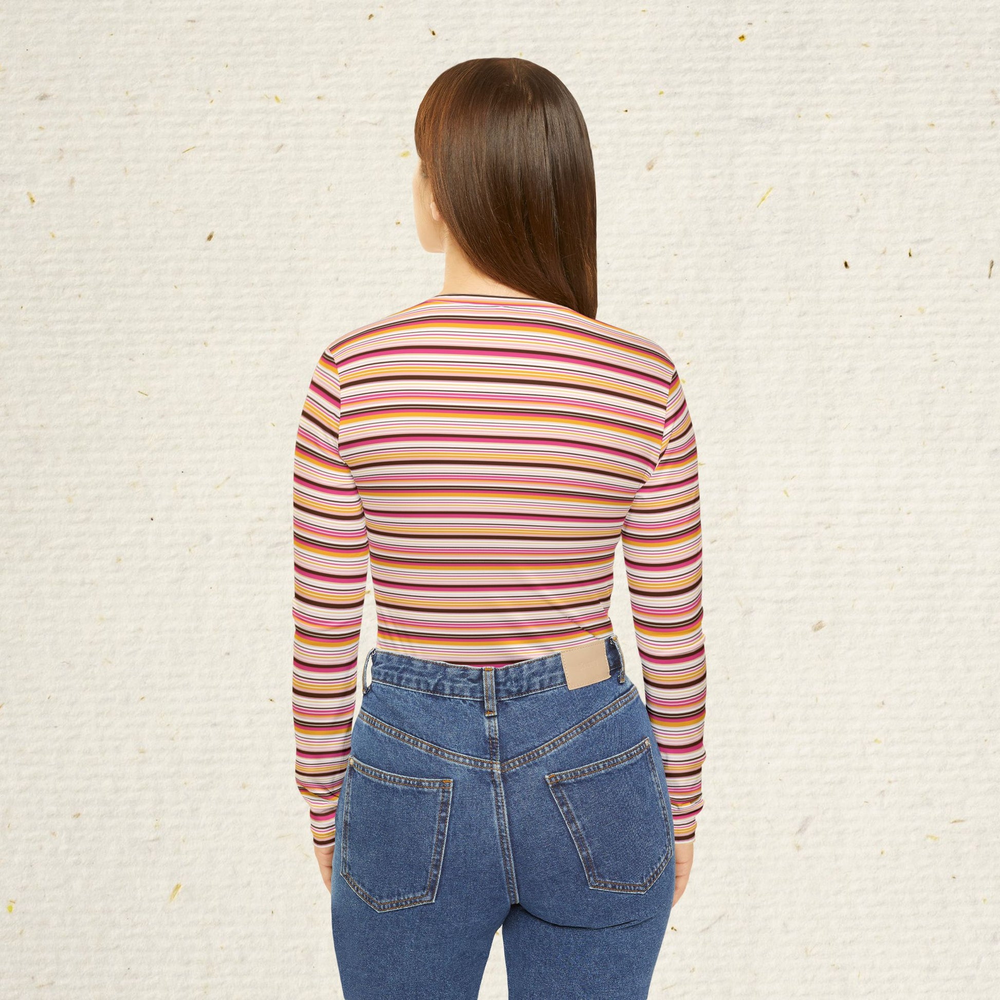 Woman wearing retro striped long sleeve V-neck top with vintage-inspired pink coral and gold stripes paired with jeans.