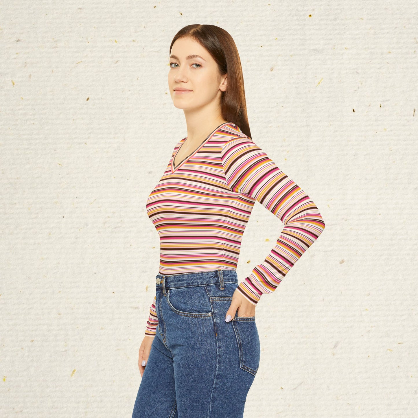 Woman wearing retro striped long sleeve V-neck top with vintage-inspired pink coral and gold stripes paired with jeans.