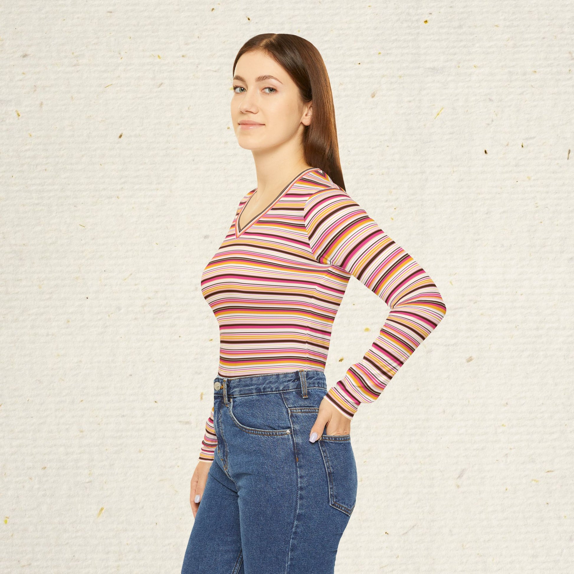 Woman wearing retro striped long sleeve V-neck top with vintage-inspired pink coral and gold stripes paired with jeans.