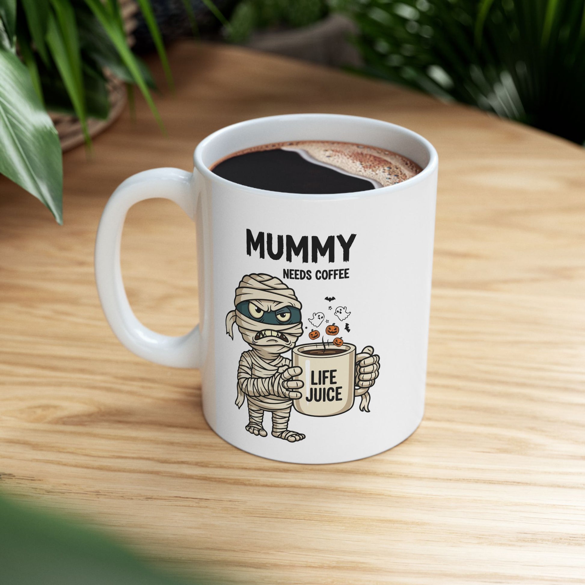 Halloween Mug with mummy design and text 'Mummy needs coffee' on a wooden surface.