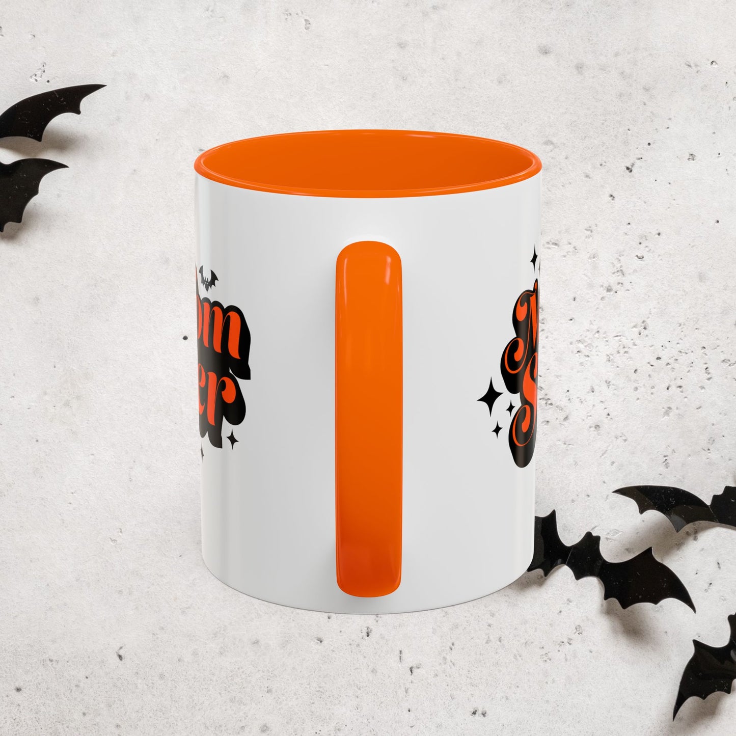 White Momster mug with orange interior and handle, featuring Halloween-themed designs on a light gray background.