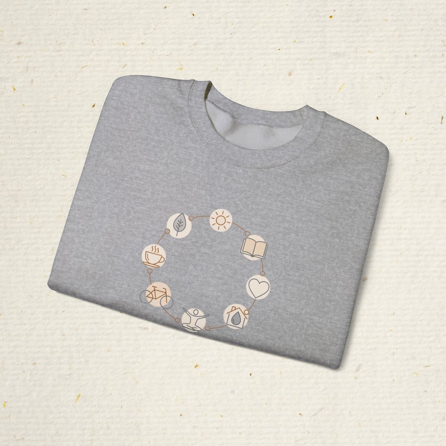 Folded gray sweatshirt with geometric pattern on a textured beige surface
