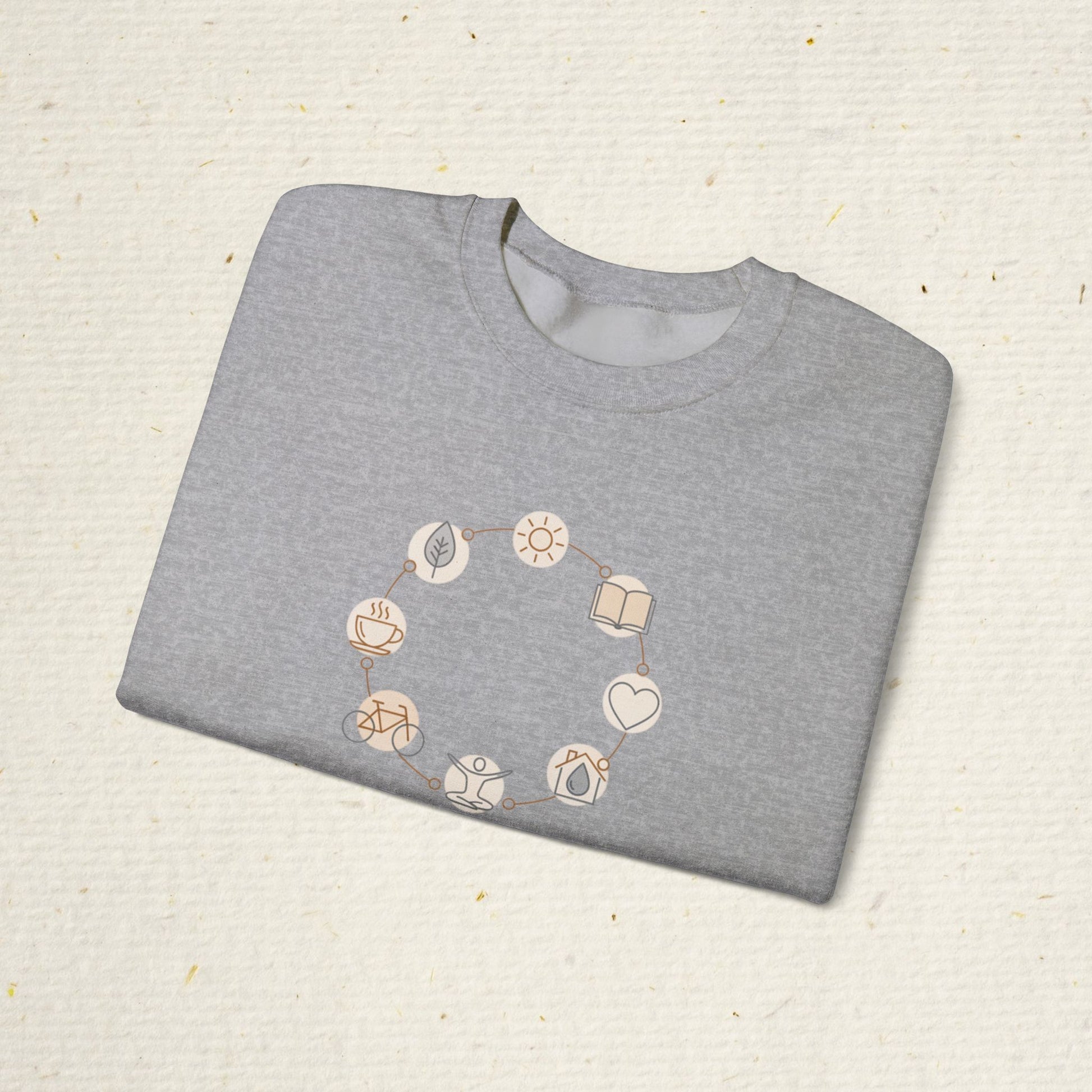 Folded gray sweatshirt with geometric pattern on a textured beige surface
