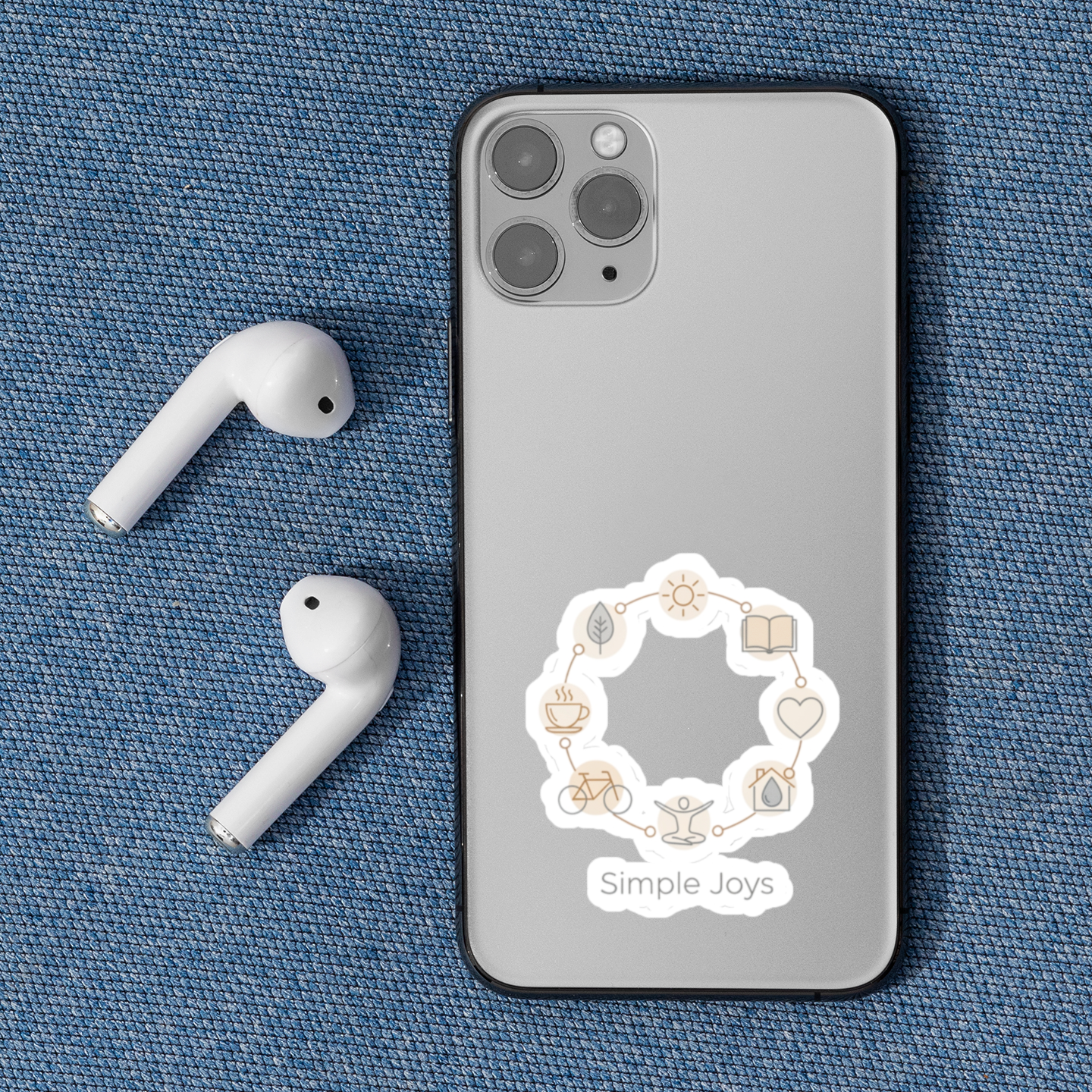 Phone case with 'Simple Joys' design on a blue fabric background