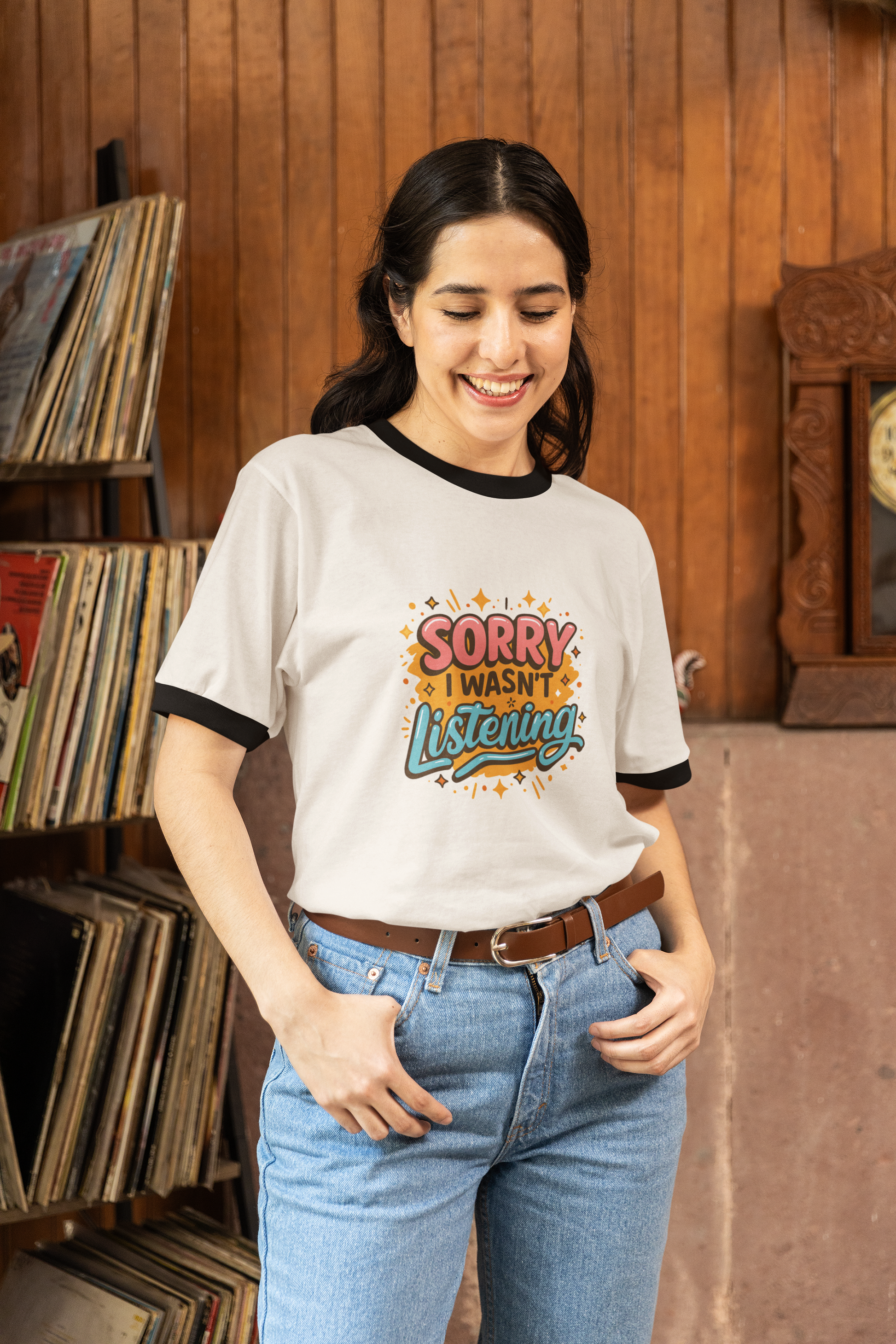 Woman wearing a going back to school t-shirt with 'Sorry I Wasn't Listening' text in a record store.