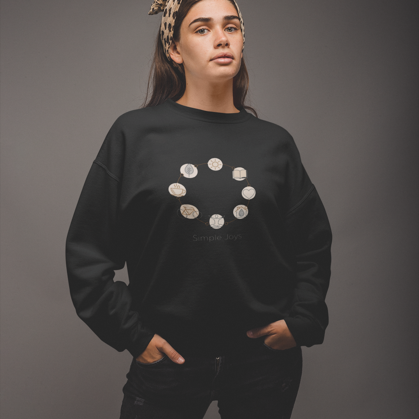 Person wearing a black sweatshirt with a circular design on a gray background